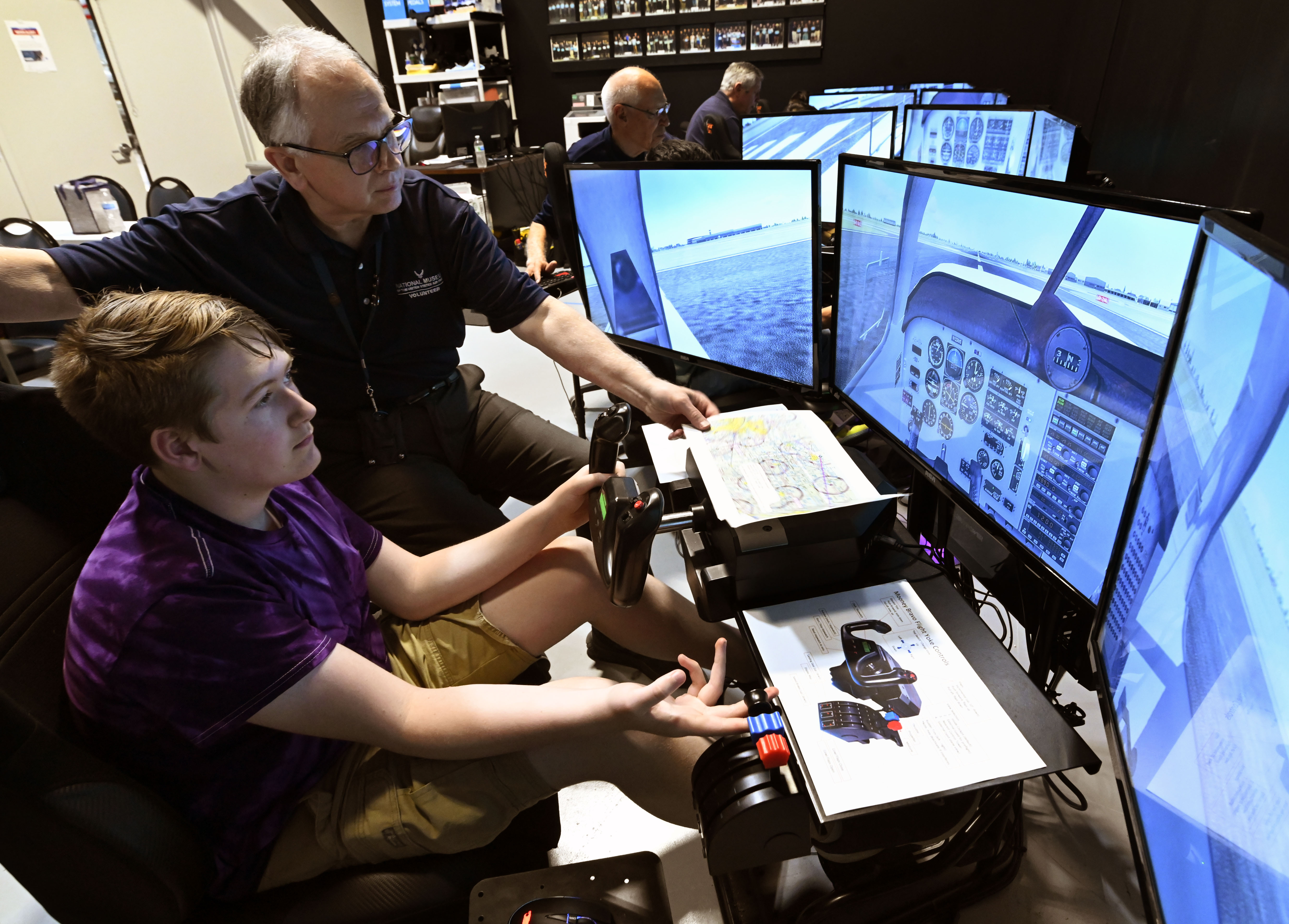 A student sits behind the simulator in the Intro to Pilot Class