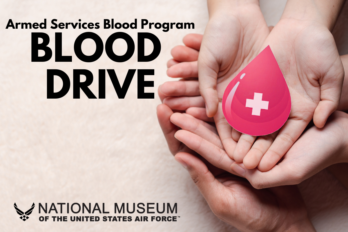 Armed Services Blood Program at the National Museum of the US Air Force with a stack of open hands holding a pink bllood drop shape with a white cross in it.