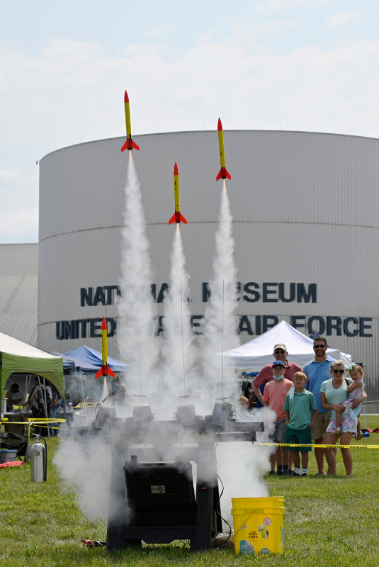 Family standing in front of the museum with rockets being set off in front of them