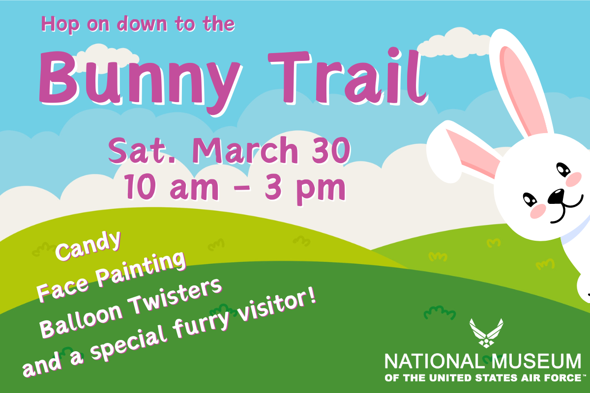 Blue cloud background with green hills in front. A cartoon bunny is leaning in from the right. Hop on down the the Bunny Trail, March 30 from 10 - 3.