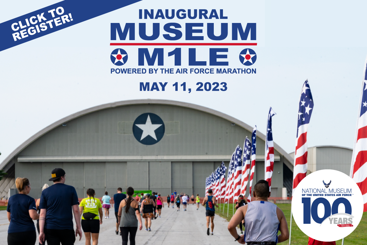 Click to register for the inaugural museum mile on May 11 sponsored by the AF Marathon. Background is a picture of the museum hangar with people walking down a flag lined path
