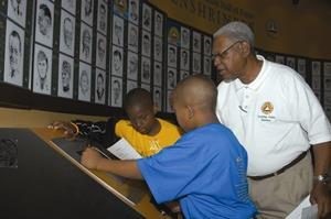 Picture of volunteer assisting two young visitors
