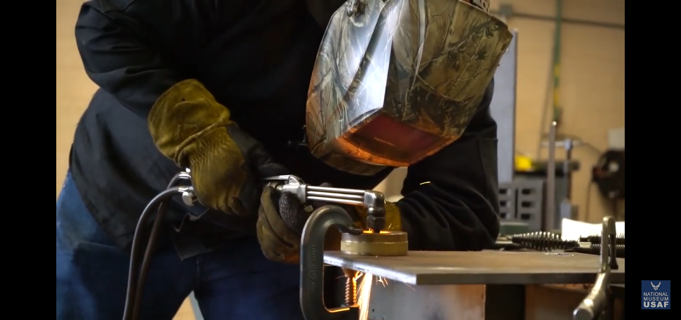 Image from video of worker welding to create exhibit display