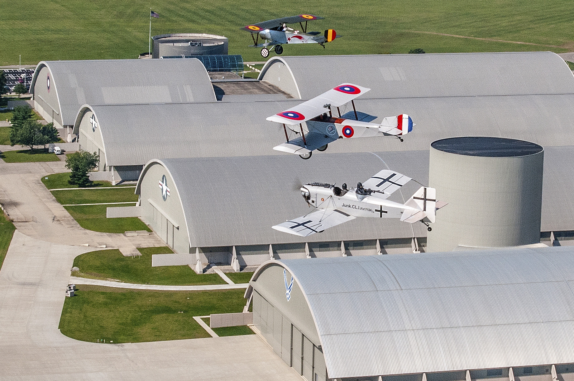 Aerial picture of World War one replica aircraft flying over the museum hangars